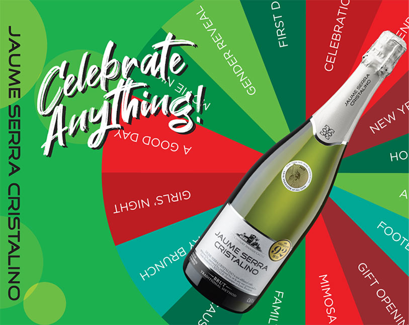 A Jaume Serra Cristalino sparkling wine bottle is angled over a colorful spinning wheel labeled with various celebration occasions. Bold text reads Celebrate Anything!! on a green background.